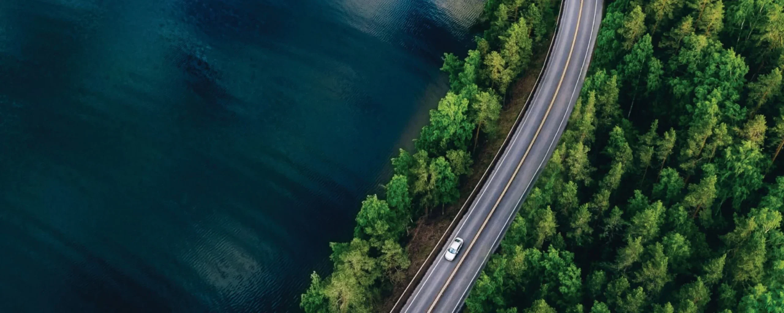Aerial view of road by blue water