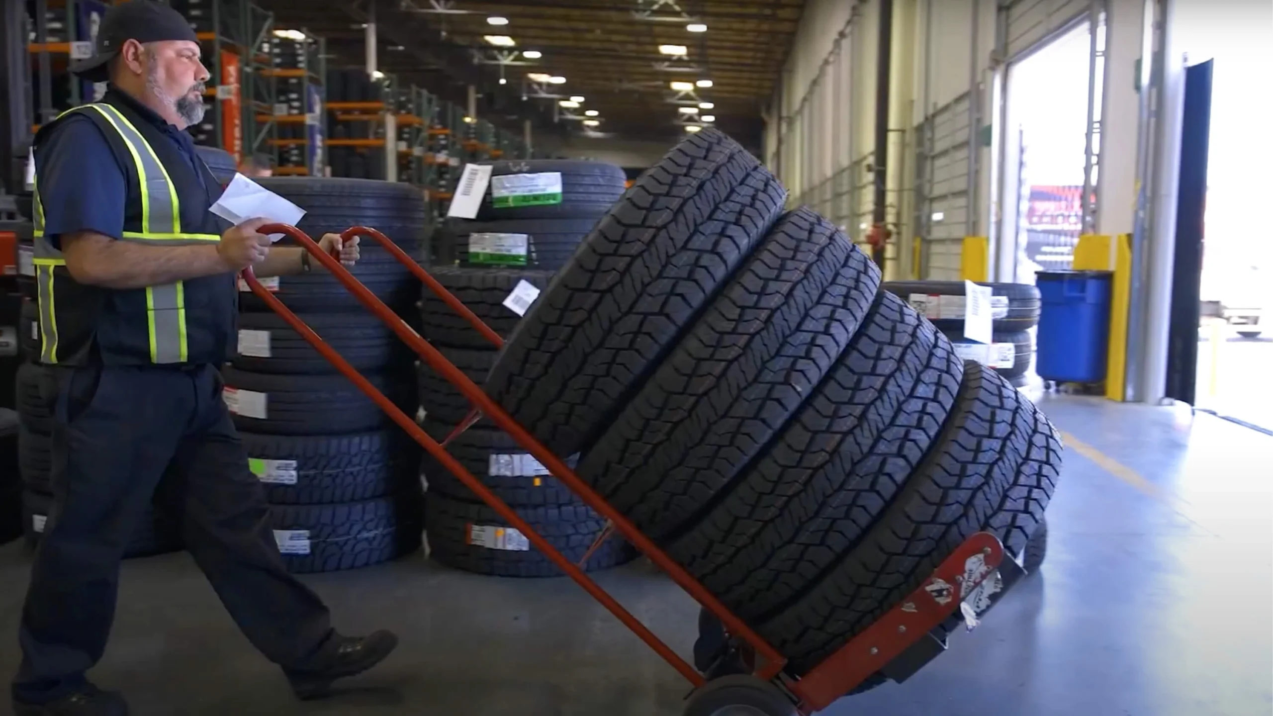 Warehouse worker moving tire stacks