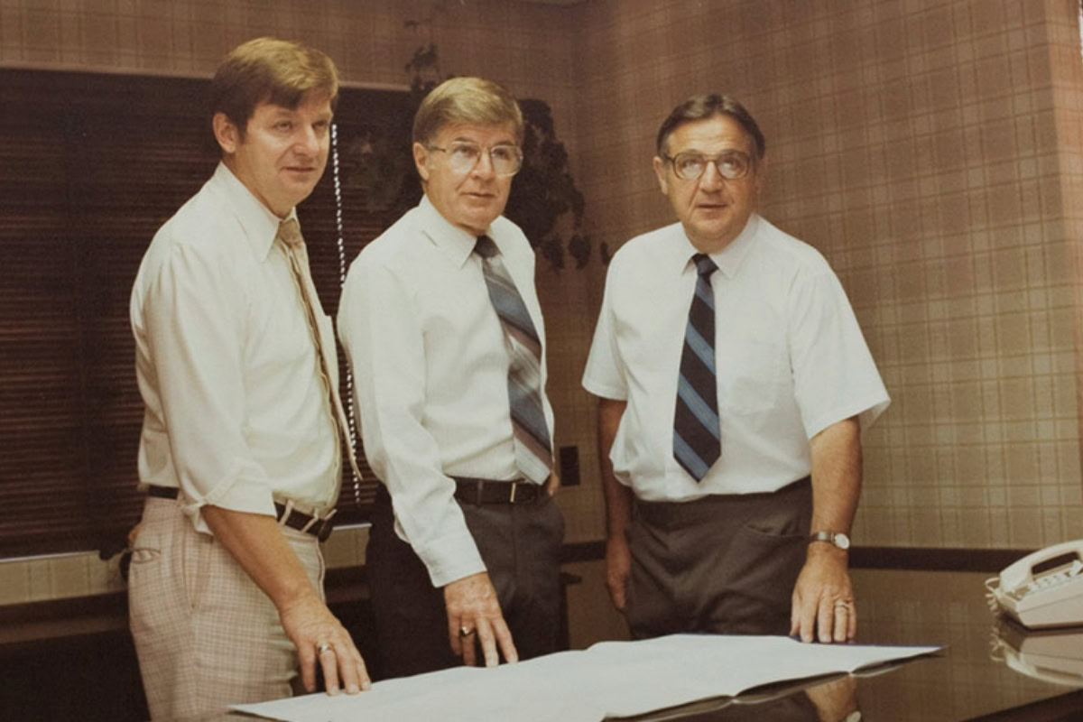 Historic photo of three men with papers