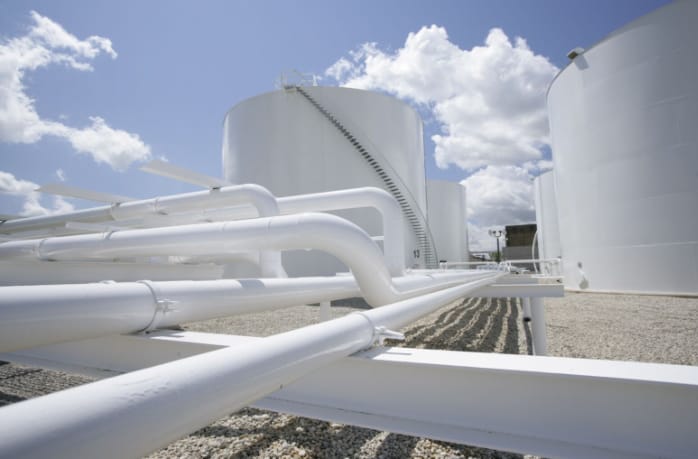 Industrial tanks and pipes under blue sky