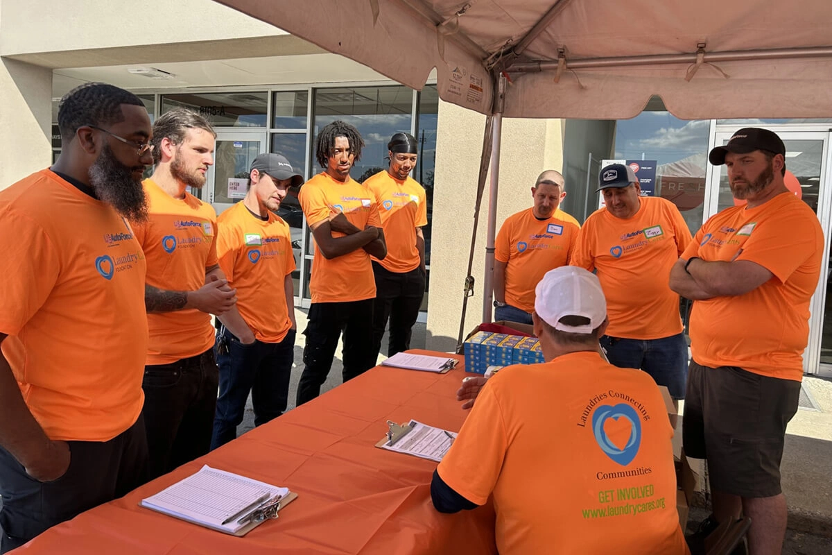U.S. Venture team members / volunteers in orange shirts registering attendees at community event