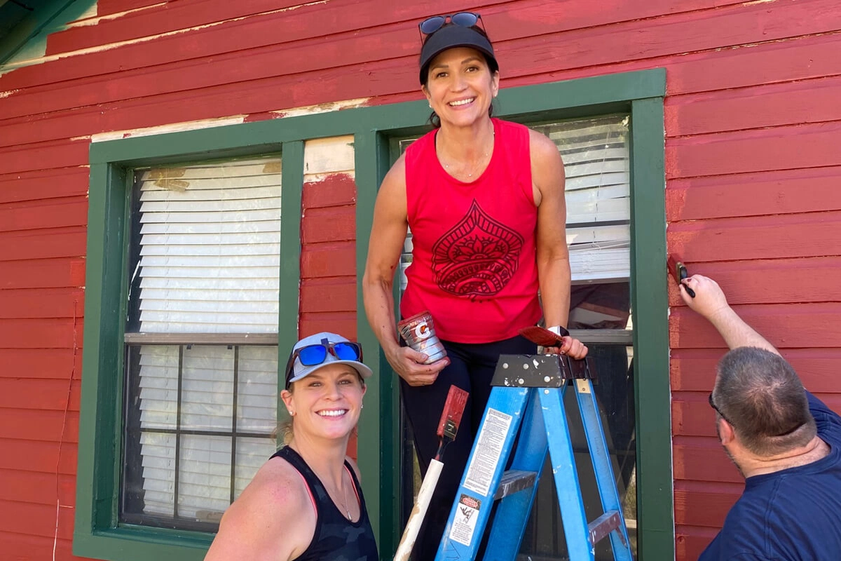 two female Volunteers working together on exterior renovation or improvement project