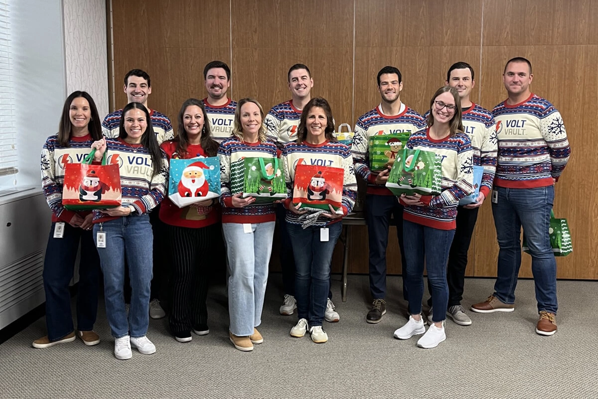 Employees proudly displaying food donations for community drive