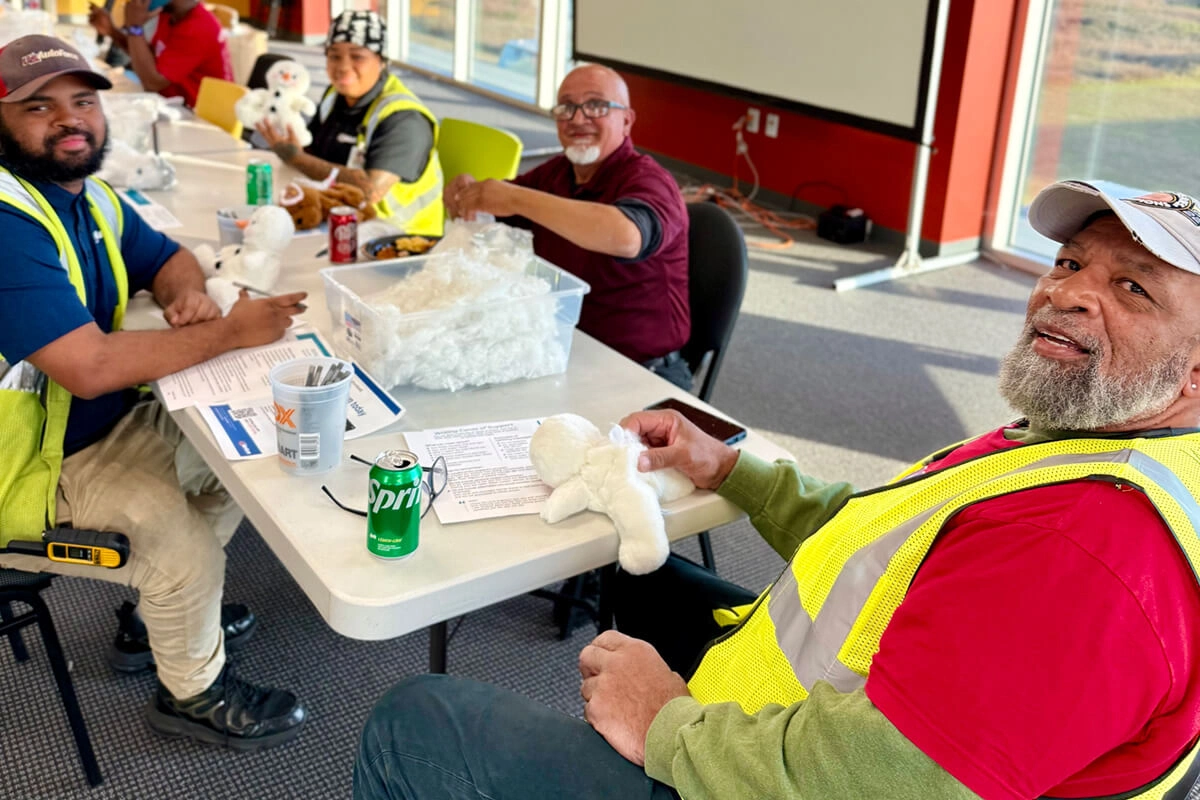 Employees at volunteer event putting stuffed animals together during break
