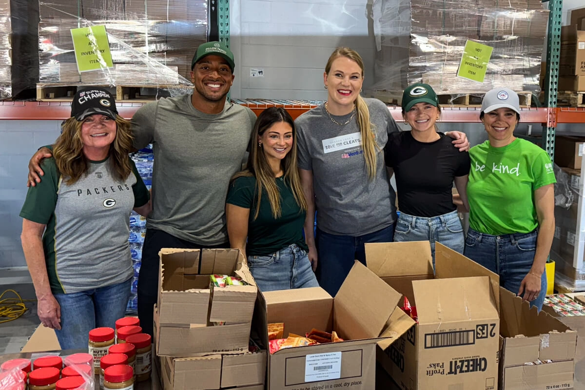 Employees packing donations during community outreach event with Aj And Gabriele Dillon