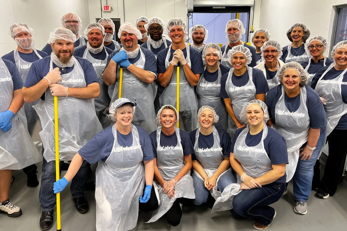 Volunteer team members in food packaging facility with protective gear