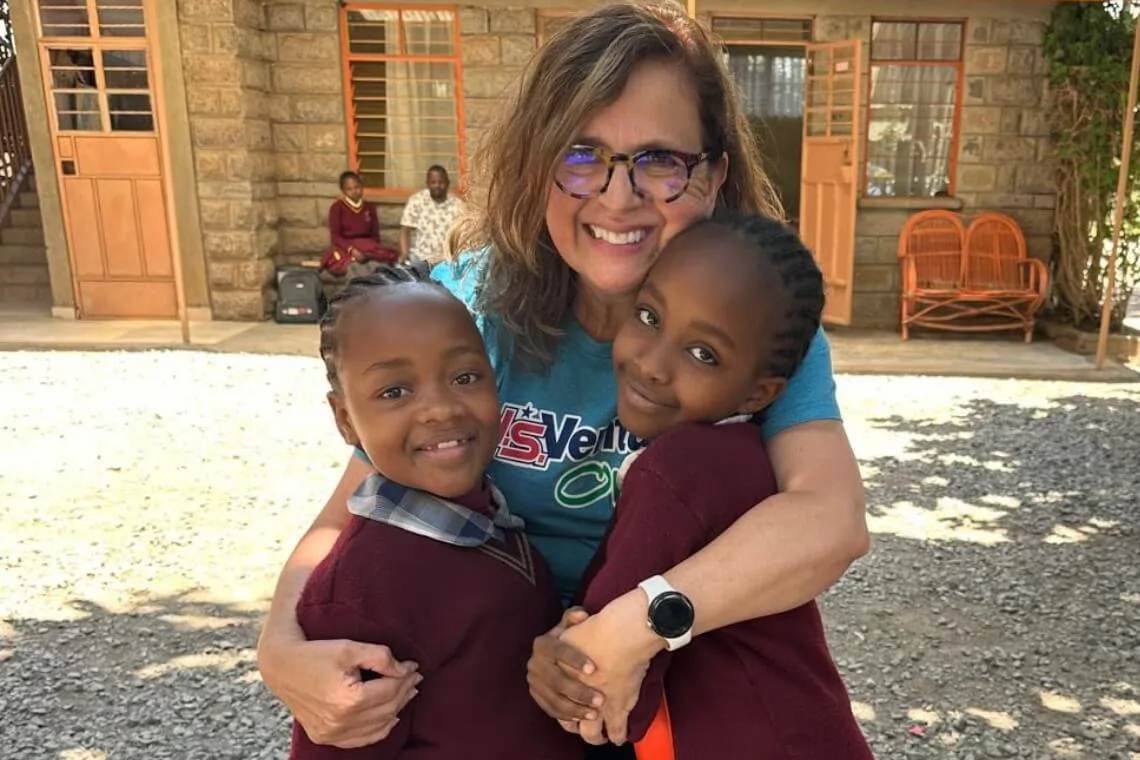 Volunteer/team member smiling with children in African village