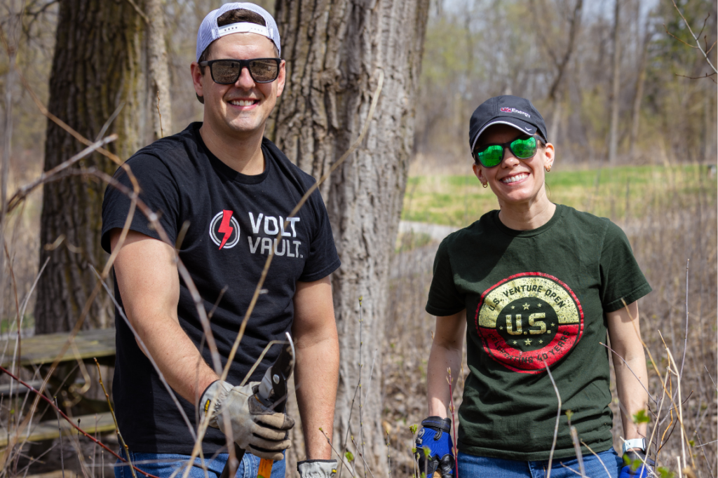 Two people picking up sticks in nature